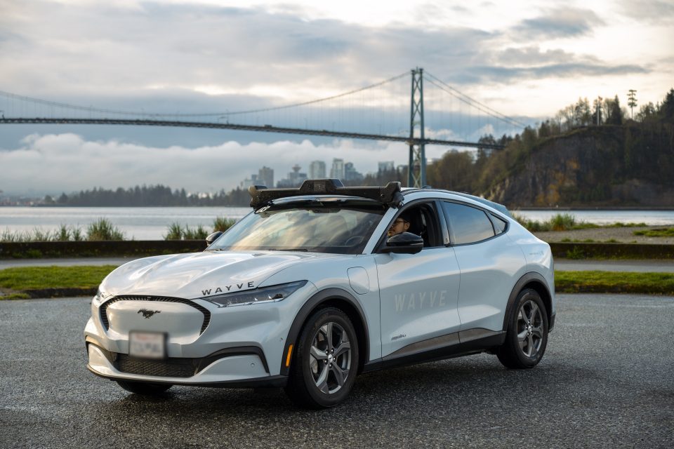 stationary car on a road with a bridge and city in the background