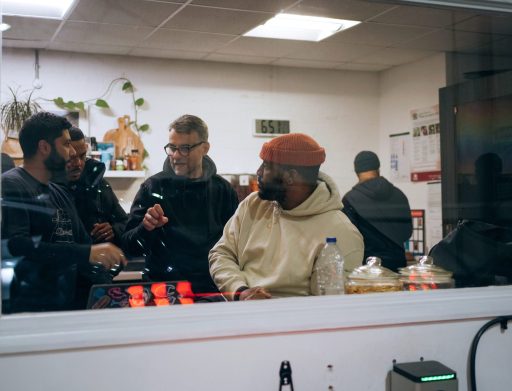 Group of Wayve employees talking in a small white room