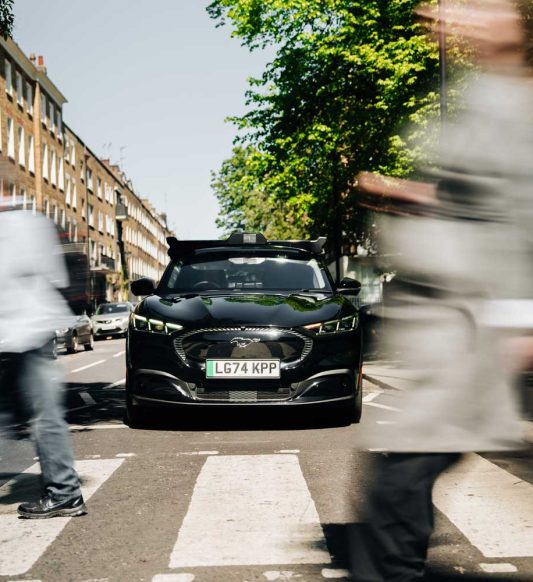 Wayve car navigating the streets in urban London at a zebra crossing