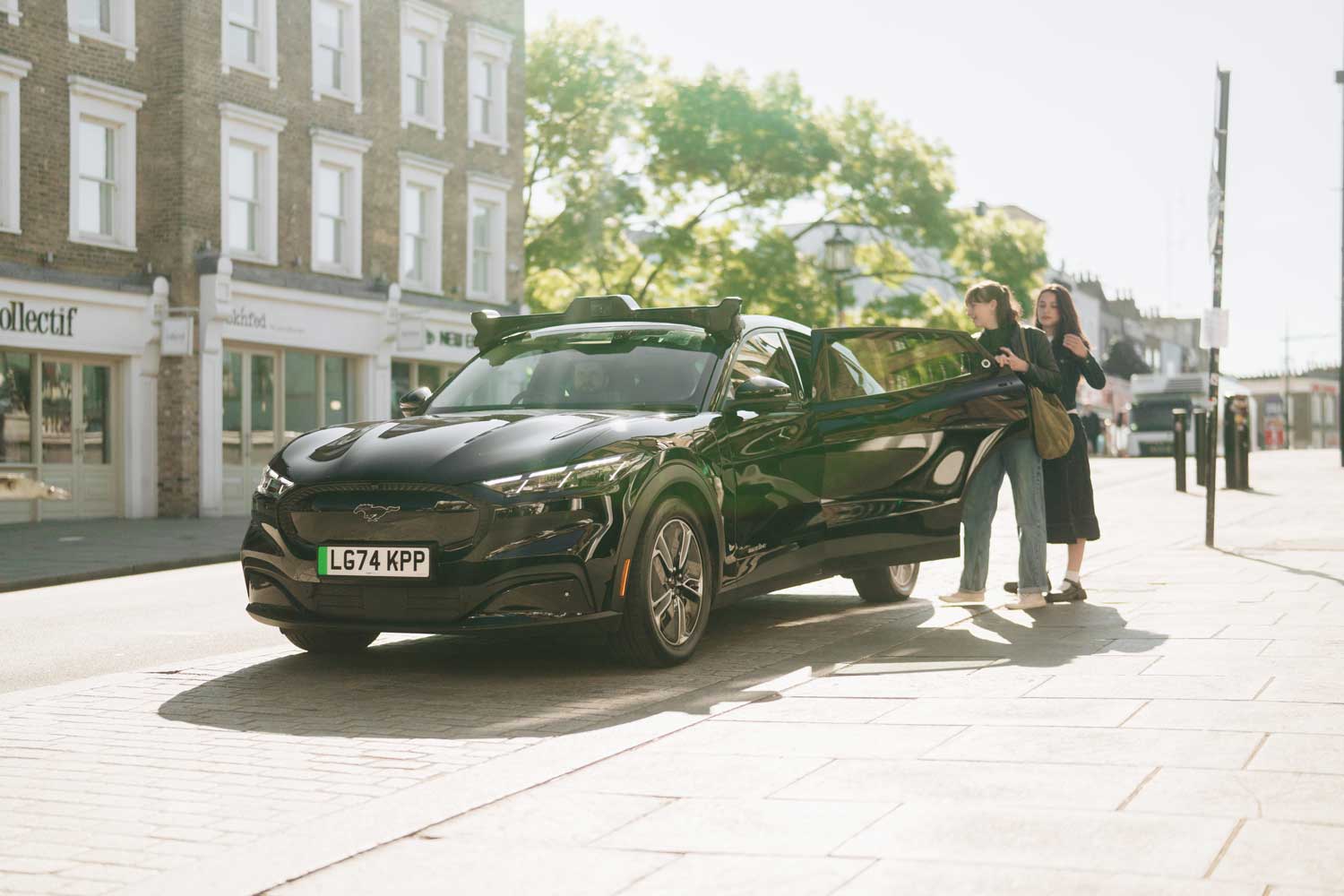 two people getting into a black autonomous car