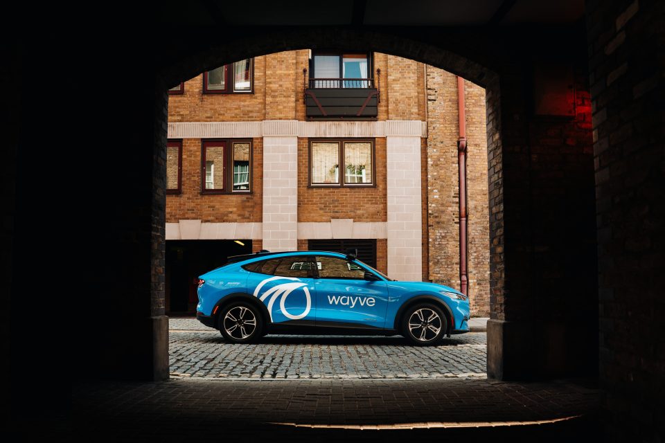blue car parked between an arch on a sunny day