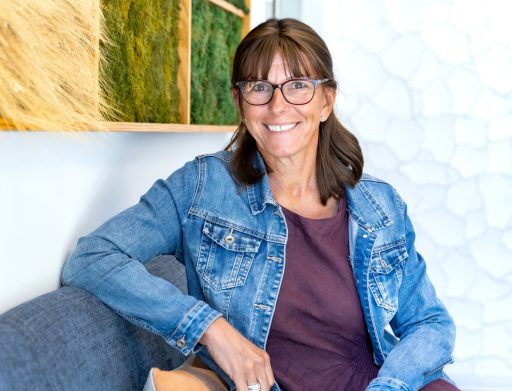 person sitting on a sofa in an office smiling at the camera
